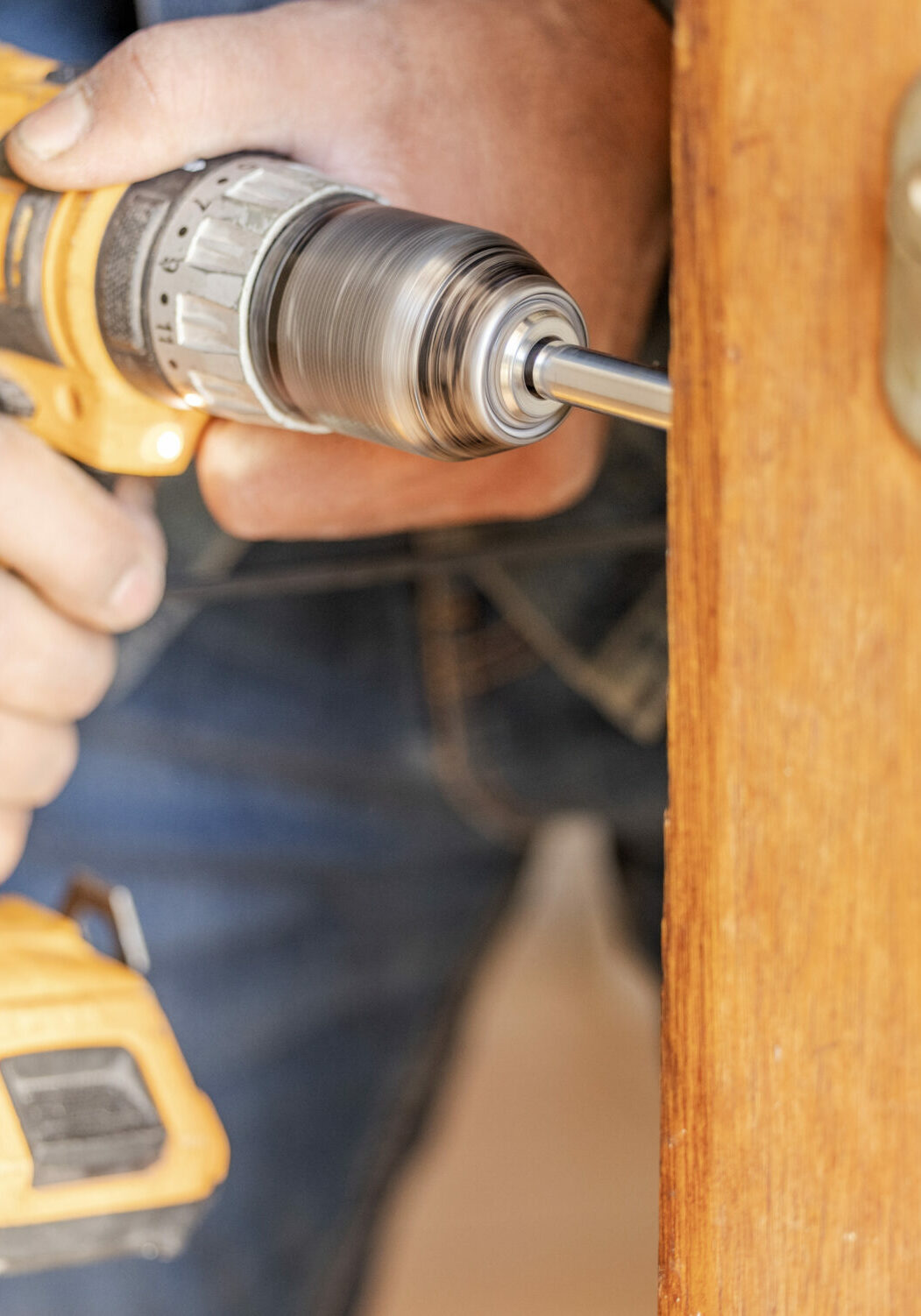 Locksmith hands, maintenance and handyman with construction and fixing, change door locks with tool.